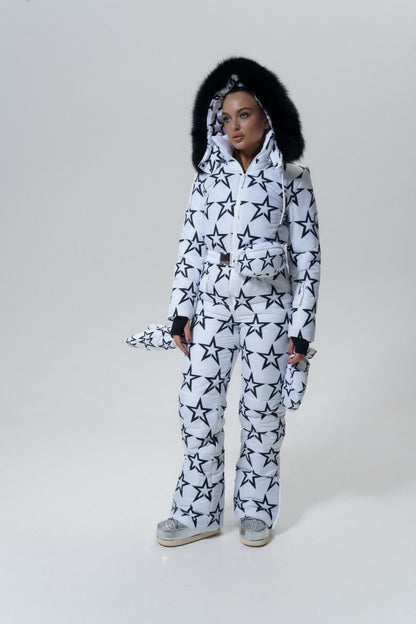 Person wearing a white snowsuit with black star patterns on a plain background