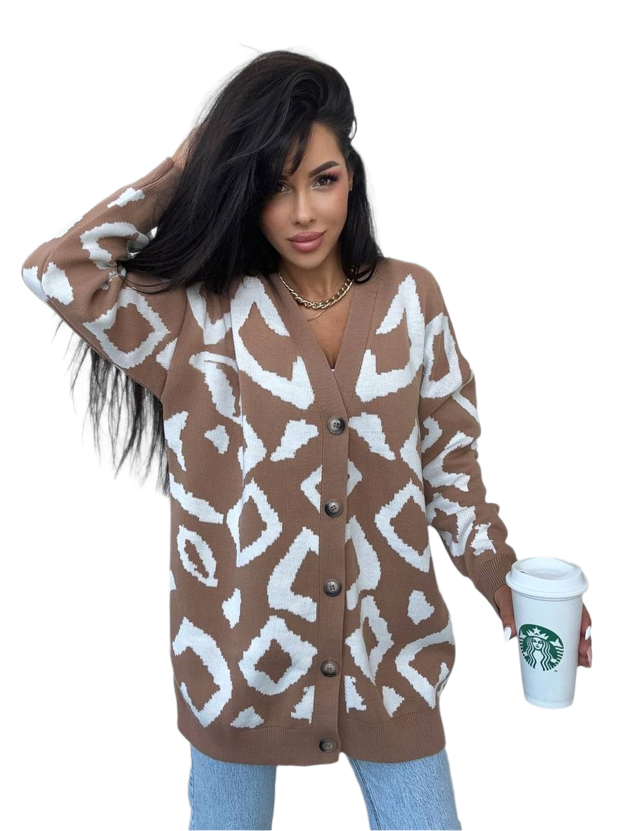 Woman wearing a brown and white patterned cardigan holding a Starbucks cup.