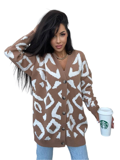 Woman wearing a brown and white patterned cardigan holding a Starbucks cup.