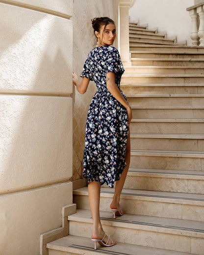 Woman in a floral dress standing on a staircase