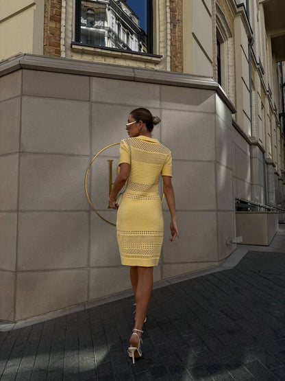 Woman in a yellow dress walking on a city street.