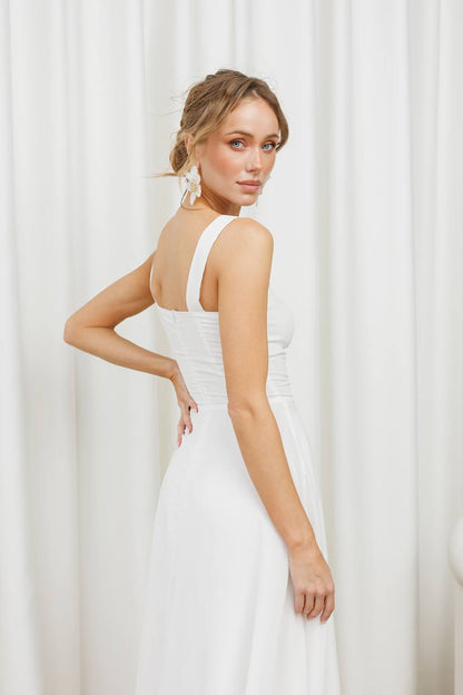 Woman wearing a white dress with a plain background