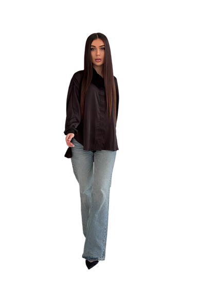 Woman wearing a black top and light blue jeans on a white background