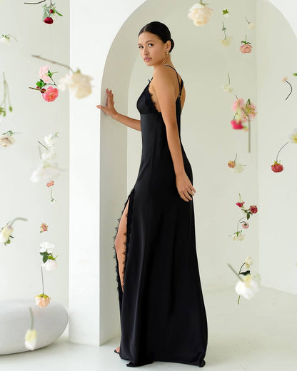 Woman in a black dress standing in a decorated room with flowers.