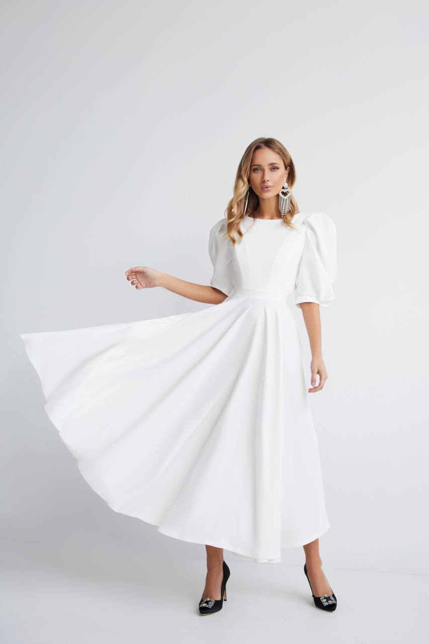 Woman wearing a white dress on a plain background