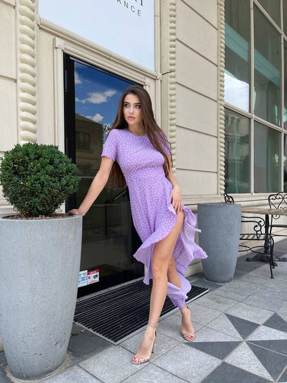 Woman in a purple dress standing outside a building