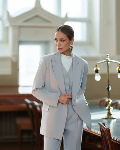 Woman in a light gray suit standing in a courtroom setting