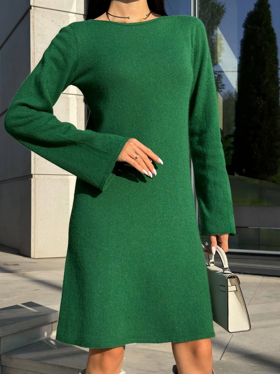 Person wearing a green dress standing outdoors.