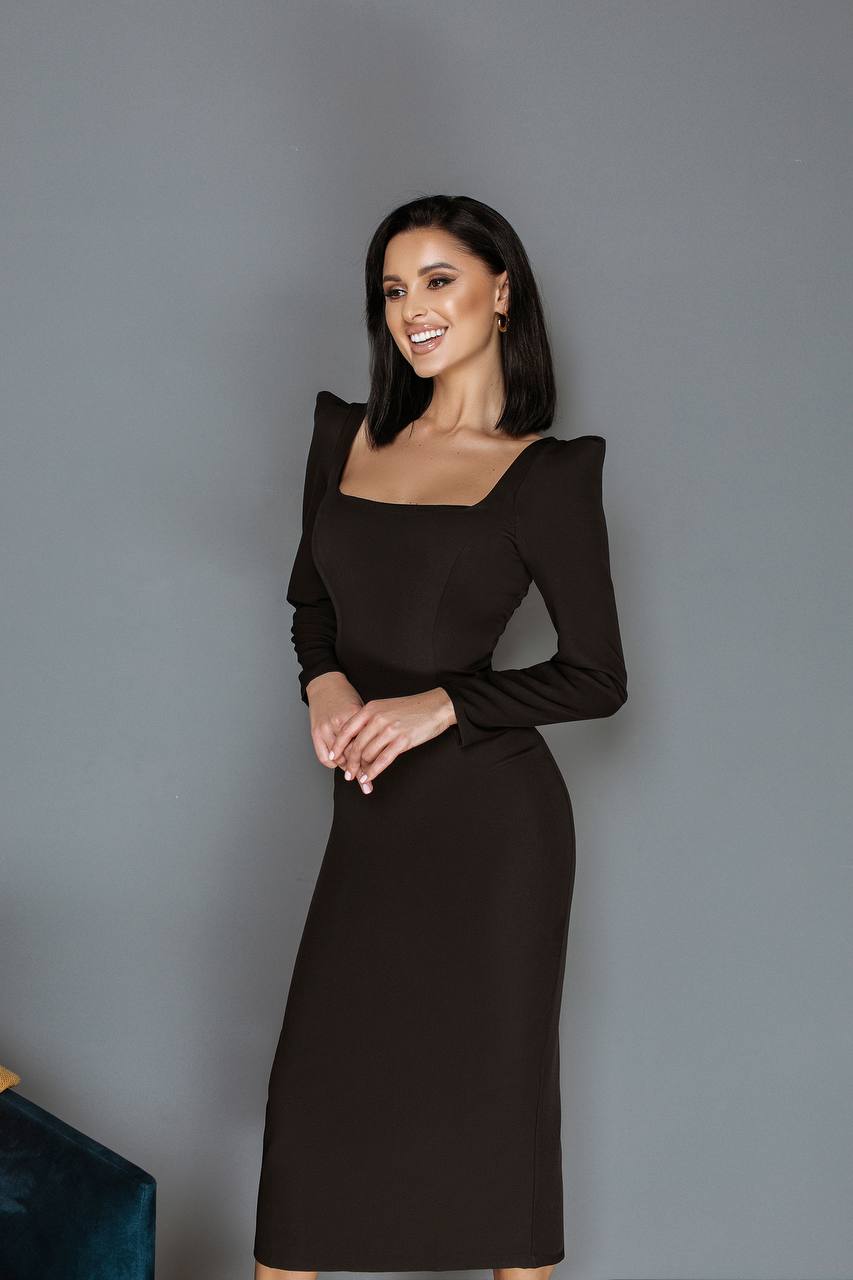 Woman wearing a black dress against a gray background