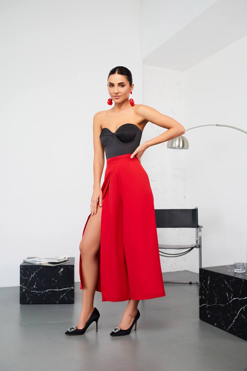Woman wearing a black top and red skirt in a modern interior setting