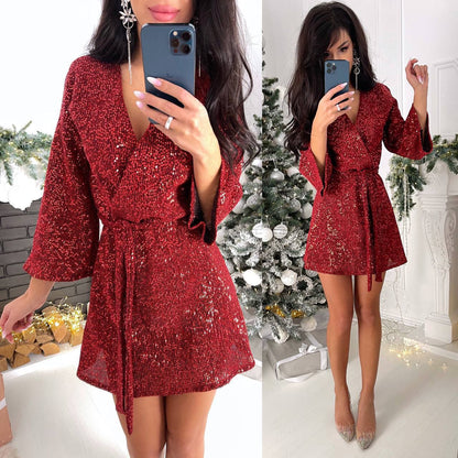 Woman in a red sequin dress taking a mirror selfie in a festive setting with Christmas decorations.