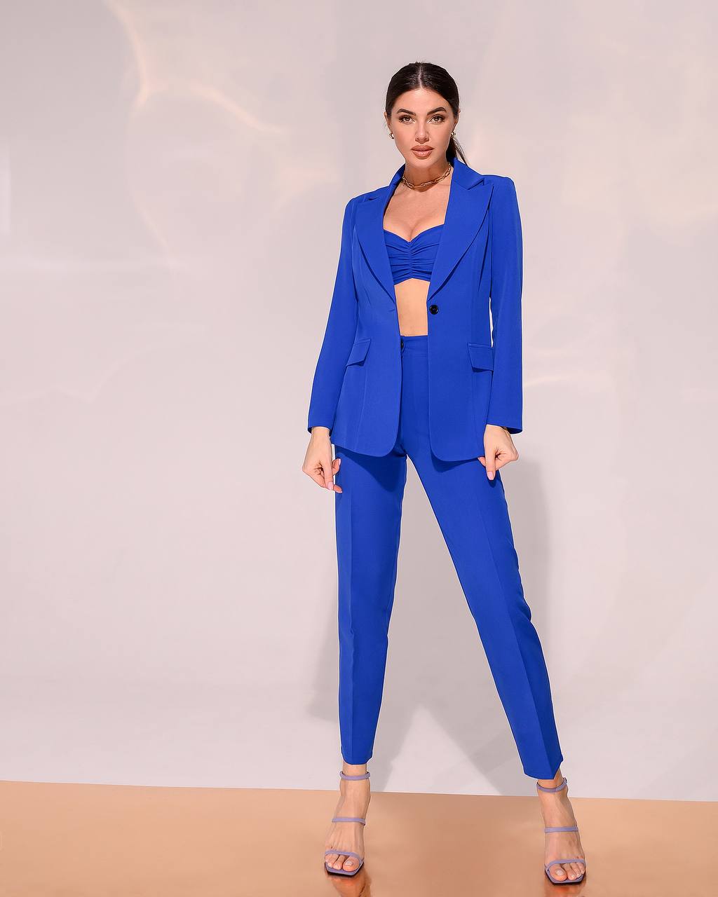 Woman wearing a blue suit against a plain background