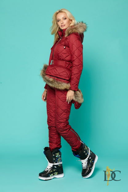 Person wearing a red winter outfit with fur trim on a teal background