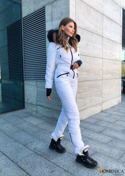 Woman in a white snowsuit walking outside a building