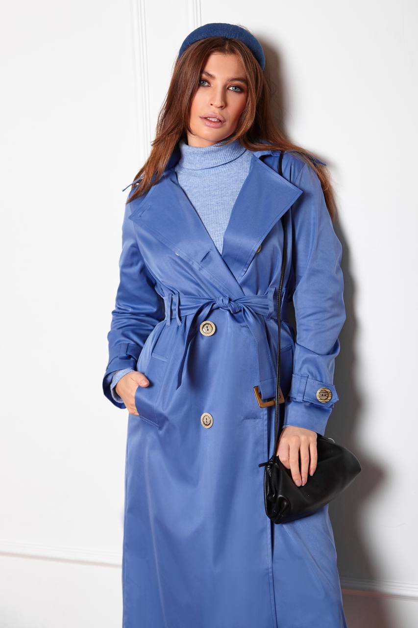 Woman wearing a blue trench coat with a white background