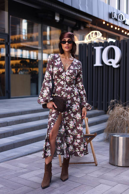 Woman in a floral dress standing in front of an IQ building.