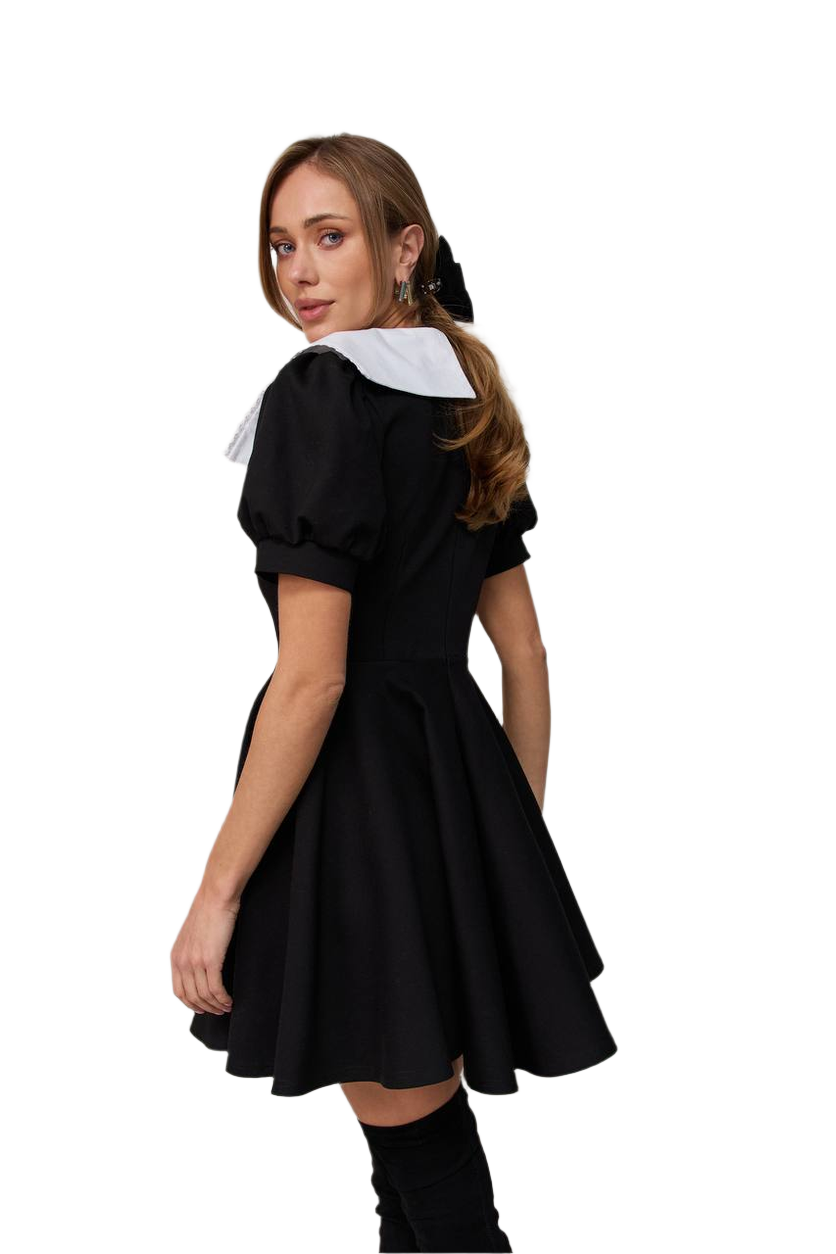 Woman wearing a black dress with a white collar on a white background