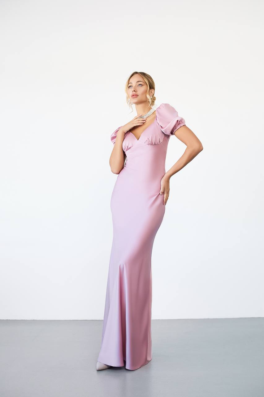 Woman wearing a pink evening gown against a white background