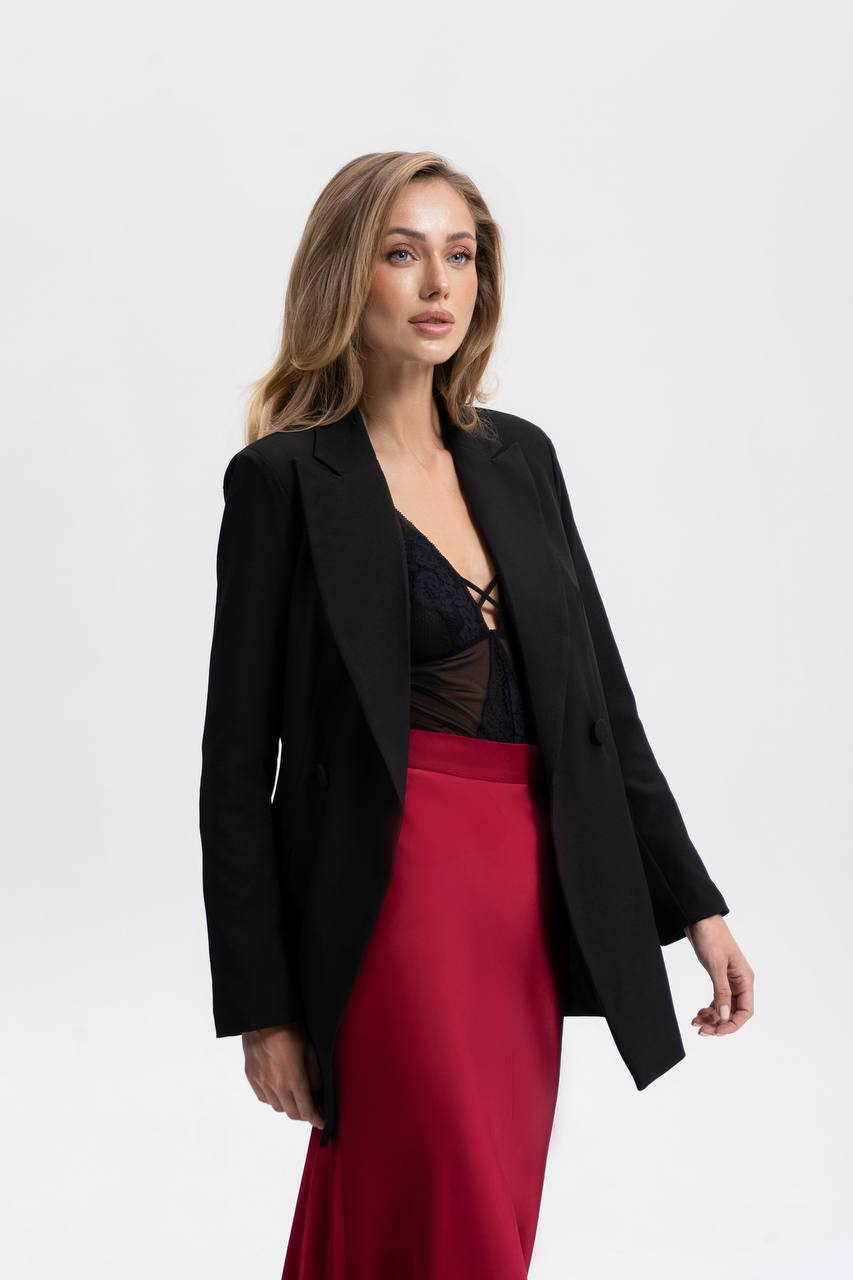 Woman wearing a black blazer and red skirt on a white background