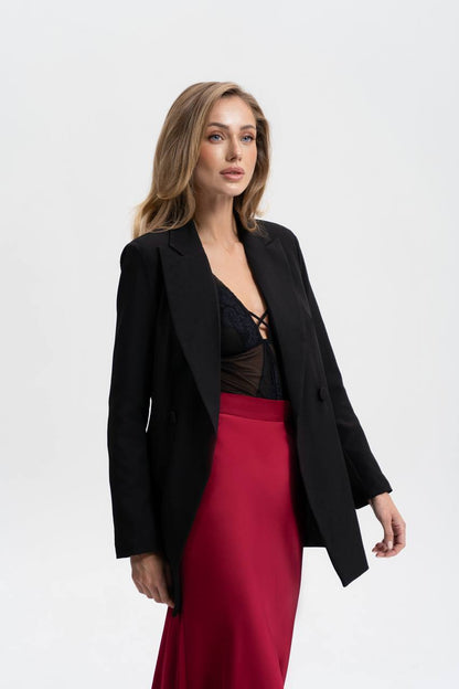 Woman wearing a black blazer and red skirt on a white background