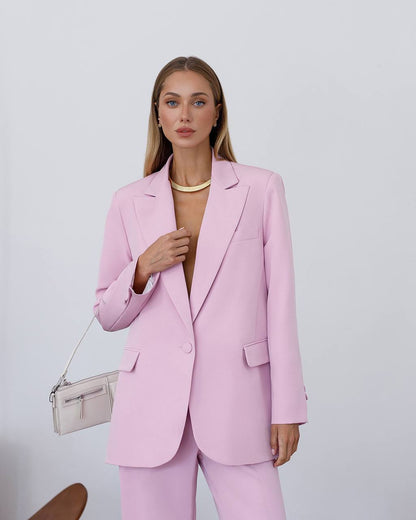 Woman wearing a pink suit with a plain background