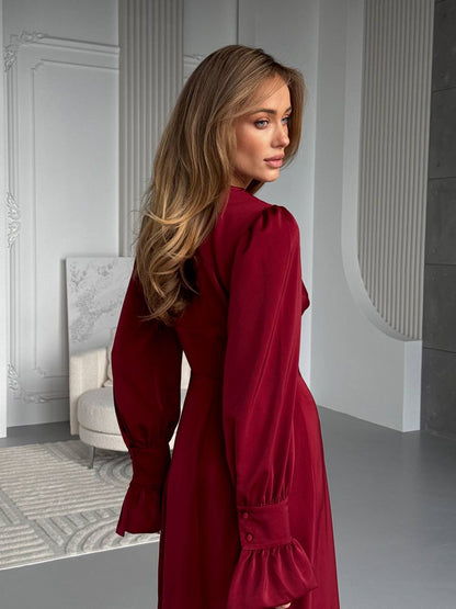 Woman in a red dress standing in an elegant interior setting
