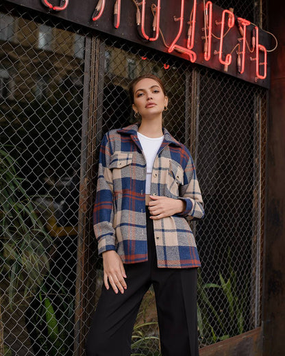 Person wearing a plaid shirt standing in front of a neon sign