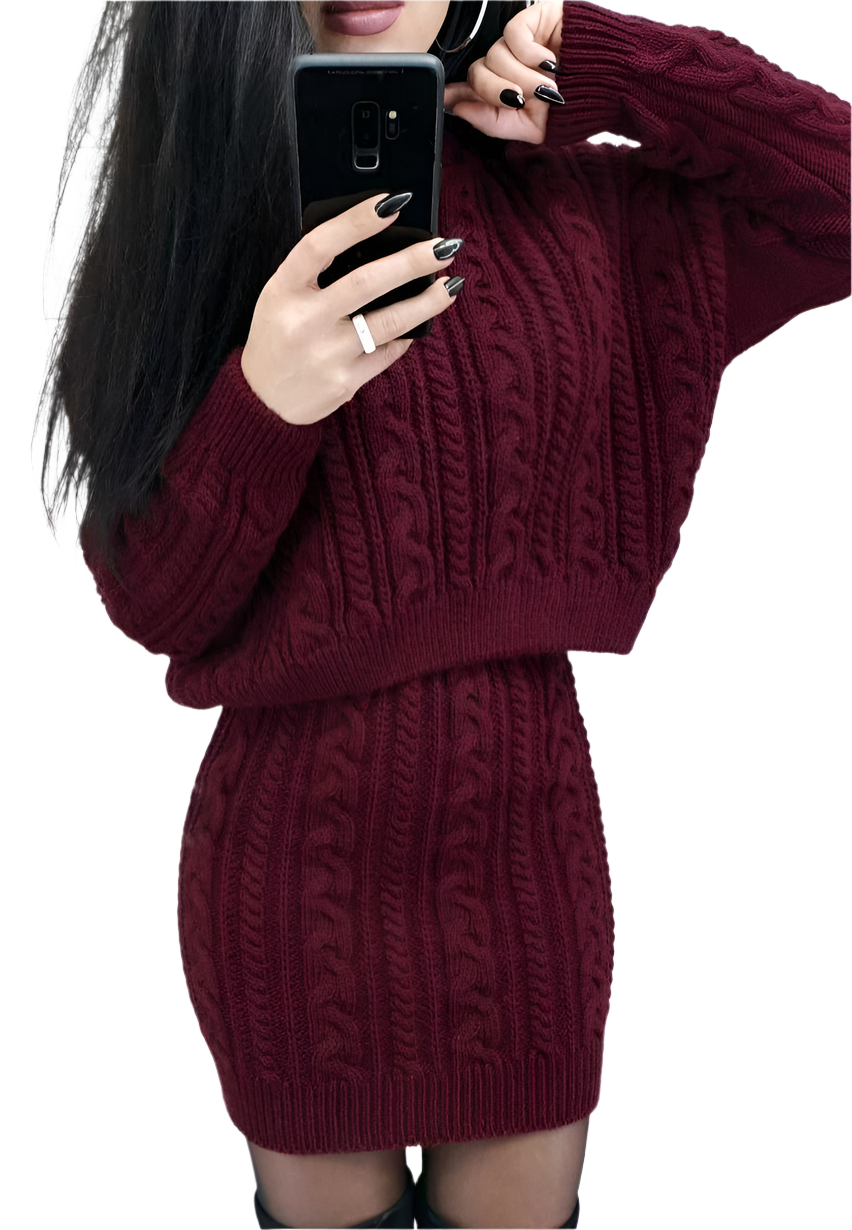 Person wearing a burgundy cable knit dress holding a phone.