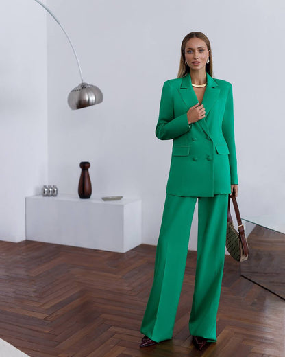 Woman in a green suit standing in a modern interior setting