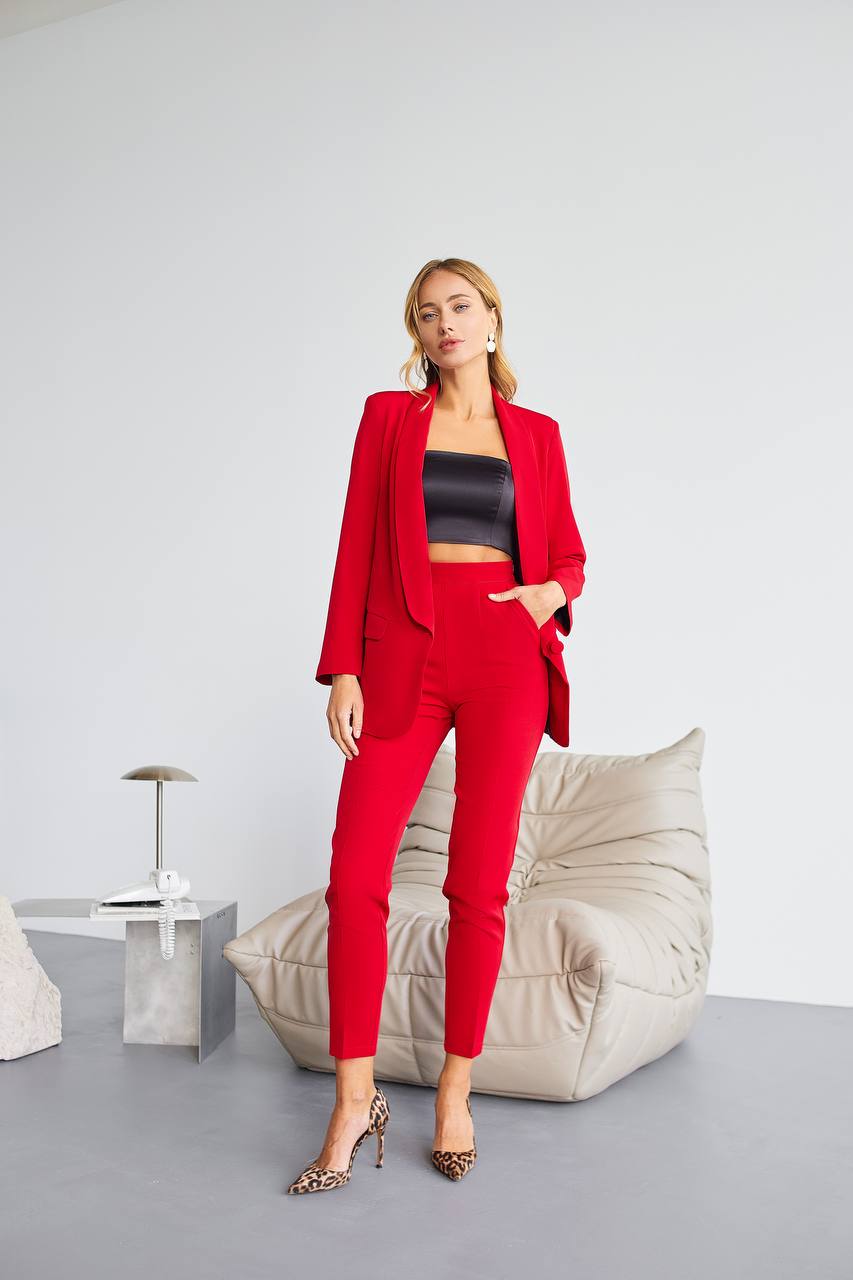 Woman in a red suit standing in a modern interior setting