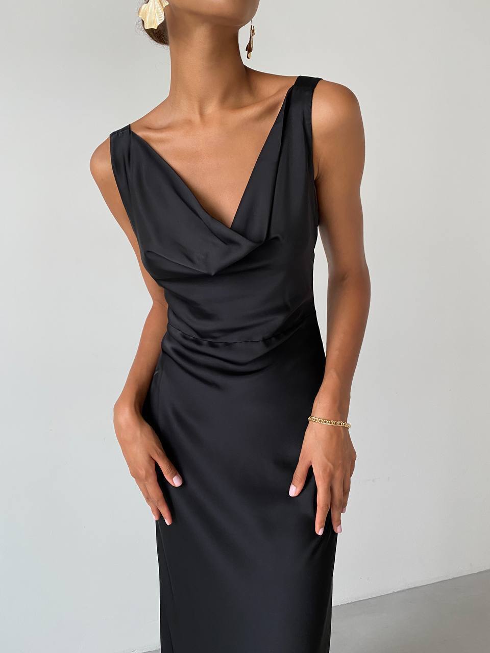 Black evening gown worn by a model against a plain background