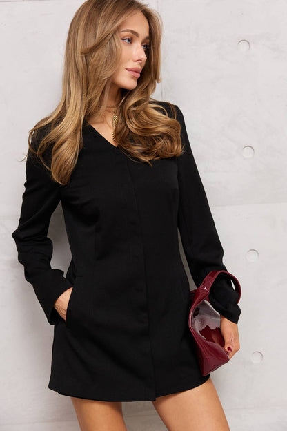 Woman wearing a black dress with a plain background