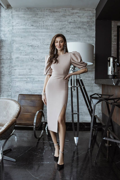 Woman in a beige dress standing in a modern interior setting