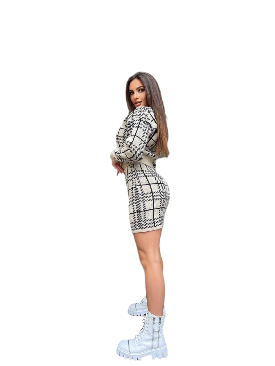 Woman wearing a black and white checkered outfit with white boots on a white background