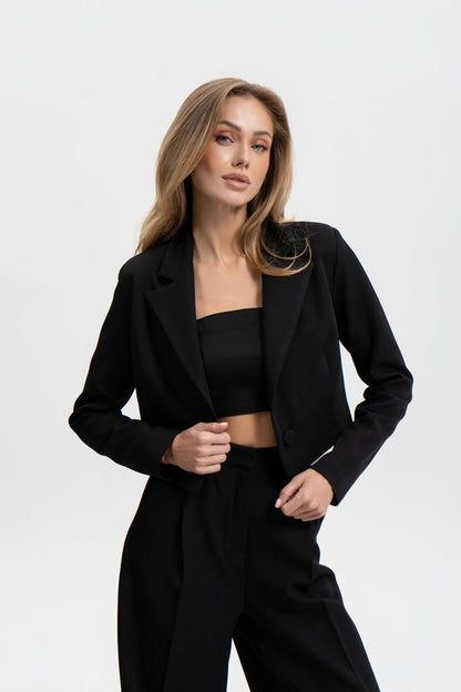 Woman wearing a black blazer and pants on a white background