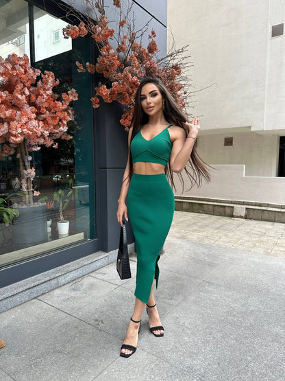 Woman in a green outfit standing on a city street with floral decorations.