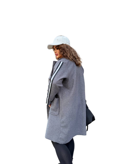Person wearing a gray coat with a white cap on a white background