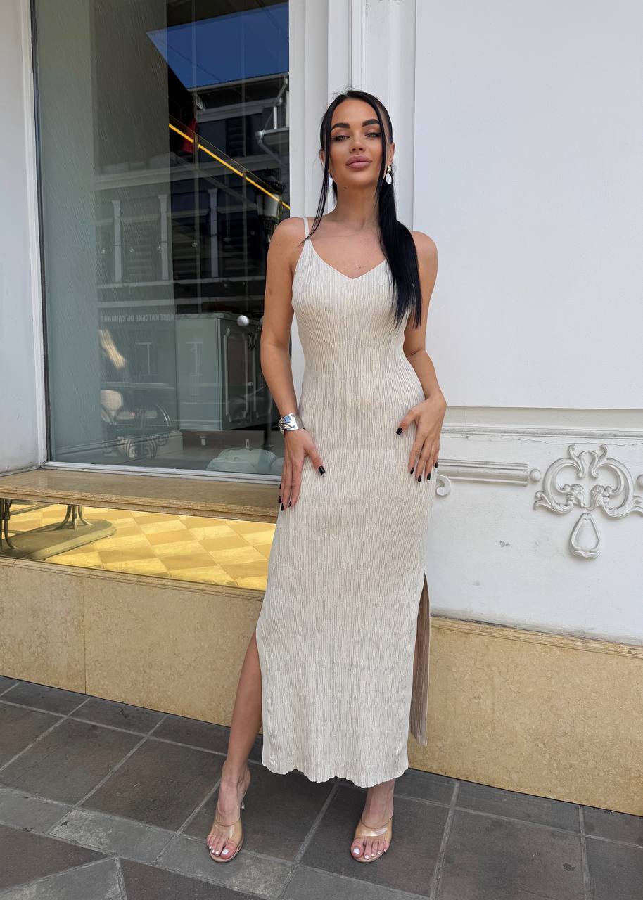 Woman in a beige dress standing outside a building