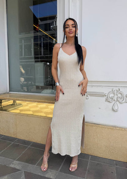 Woman in a beige dress standing outside a building