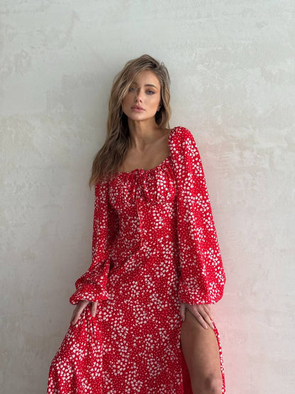 Woman wearing a red floral dress against a light background