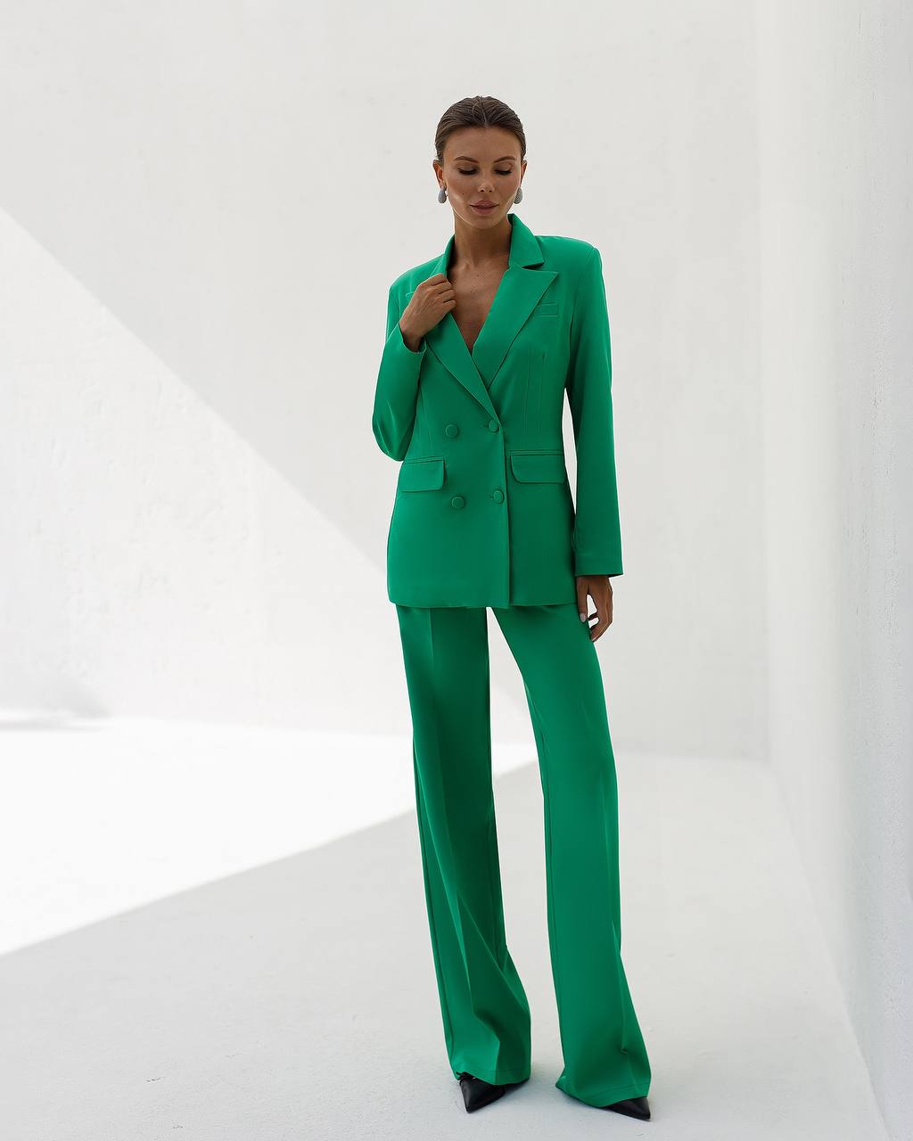 Woman wearing a green suit against a white background
