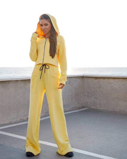 Person wearing a yellow tracksuit on a rooftop.