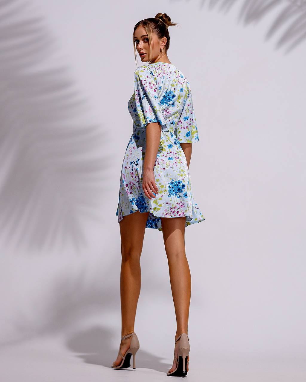 Woman wearing a floral dress against a white background