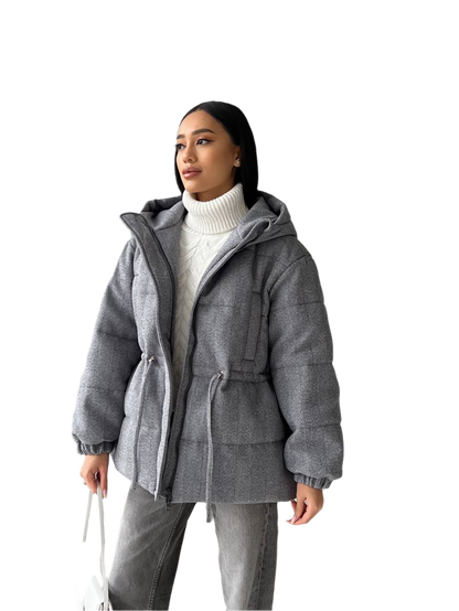Woman wearing a gray hooded jacket on a white background
