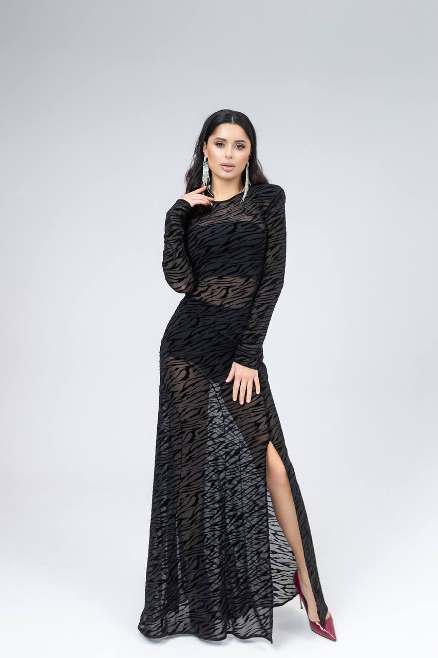 Woman wearing a black patterned dress on a white background