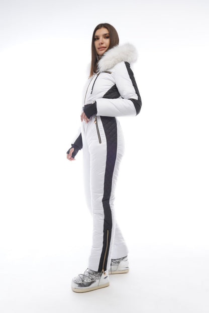 Person wearing a white and black ski suit with fur trim on a white background