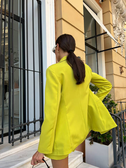 Person wearing a bright yellow outfit standing in front of a building entrance.