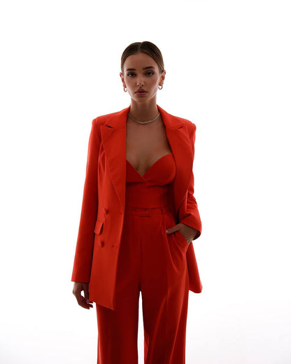 Woman wearing a bright red suit on a white background