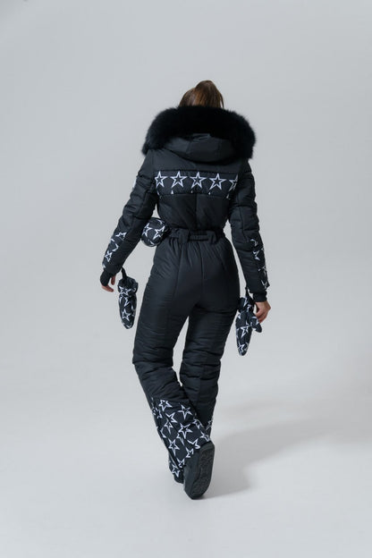 Person wearing a black snowsuit with star patterns on a white background
