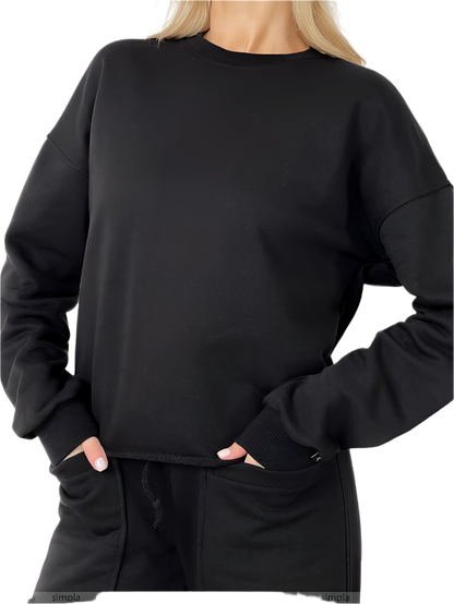 Person wearing a black sweatshirt and pants on a white background